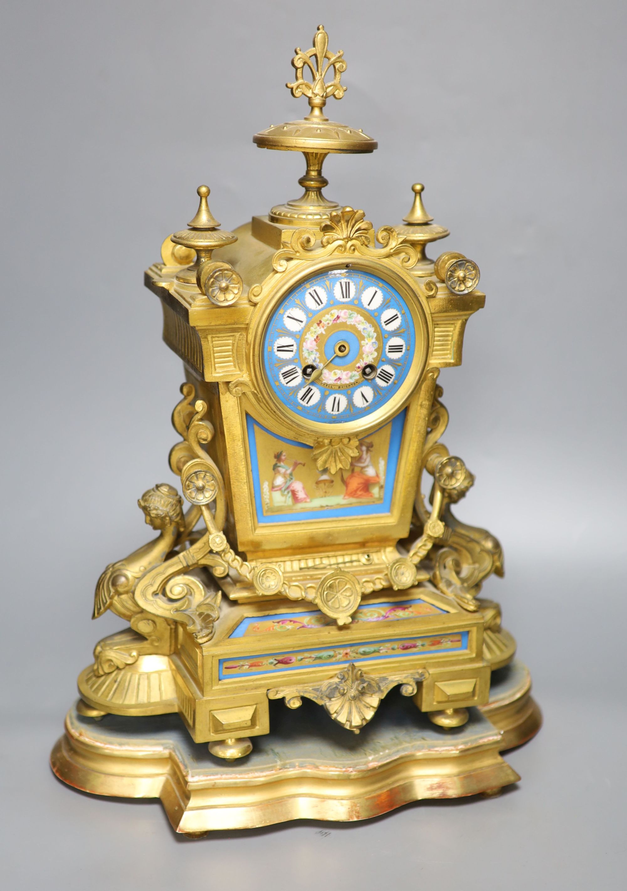 A French gilt metal and Sevres style porcelain mounted mantel clock, on plinth, with key and pendulum, overall height 49cm